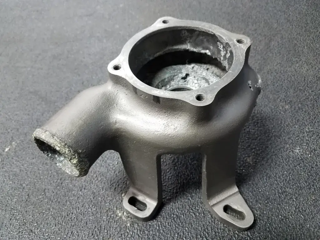 Pompe à eau d'origine présentant de nombreux trous et signes de corrosion