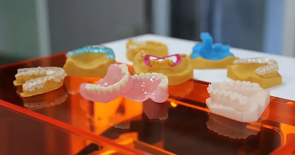 assortiment de moules, prothèses et pièces dentaires imprimés en 3D