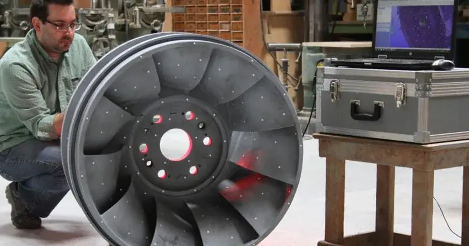 une personne se tenant à côté d'une pièce de fonderie dans un environnement industriel