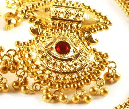 boucle d'oreille en or travaillée avec un rubis au milieu