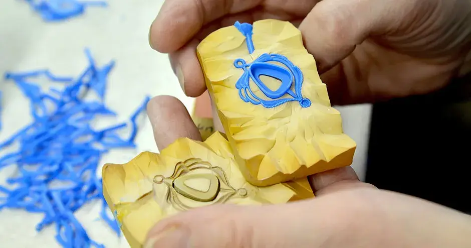 pendentif en cire bleue avec un chaton triangulaire arrondi dans un moule en caoutchouc jaune