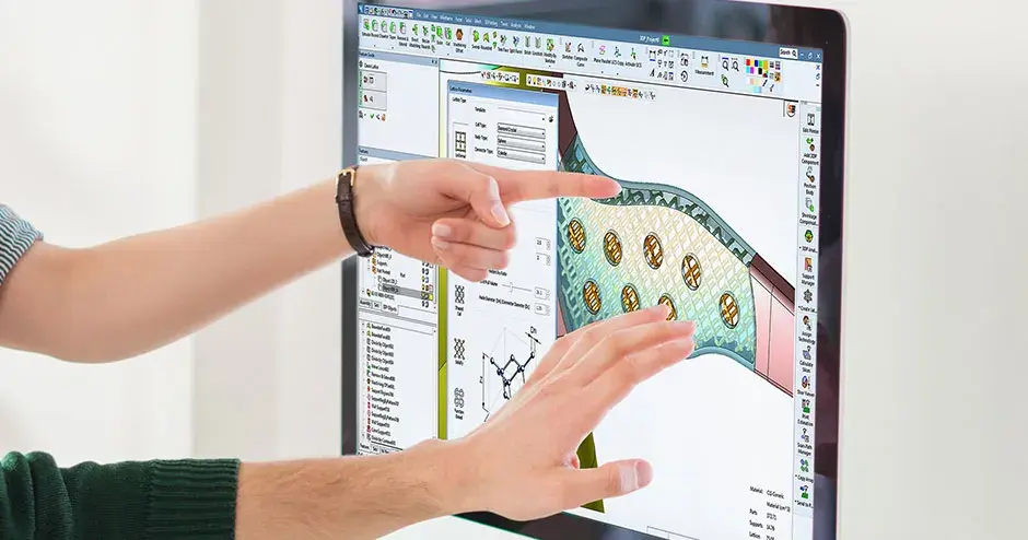 2 personnes pointant vers un écran d'ordinateur