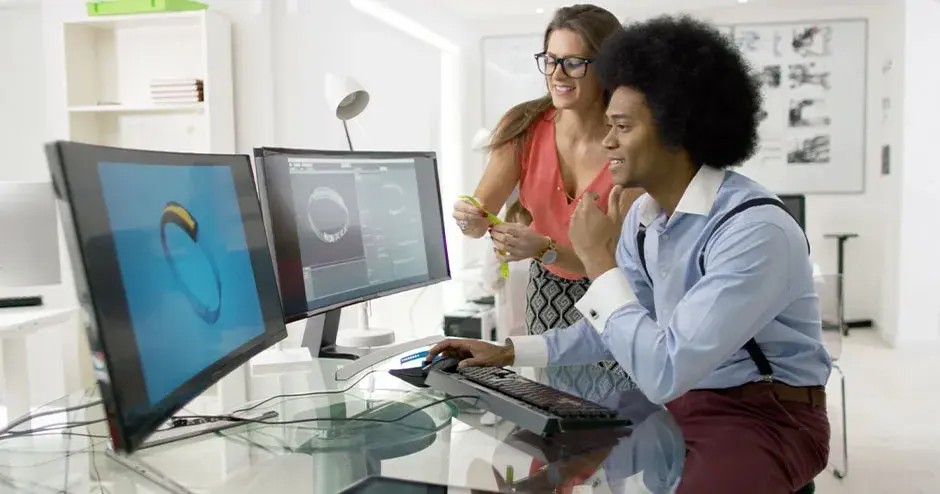 2 personnes conçoivent une montre et éditent le fichier sur un grand écran