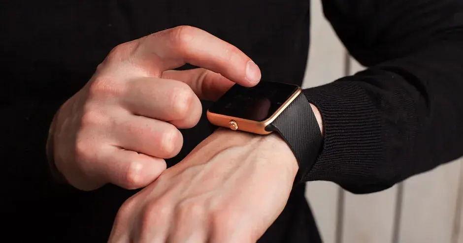 un homme portant une montre et montrant les caractéristiques de la montre