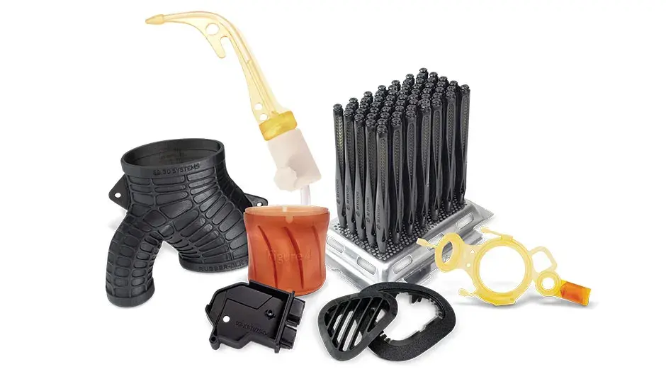 Plusieurs pièces imprimées en 3D sont exposées sur fond bleu. Parmi elles, un engrenage blanc, un modèle médical coloré et d'autres pièces de production noires et grises unies.